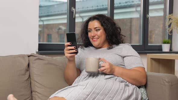 Woman with Smartphone Drinking Coffee at Home