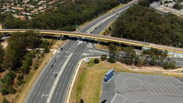 Time lapse busy highway aerial view with light rail tram crossing.