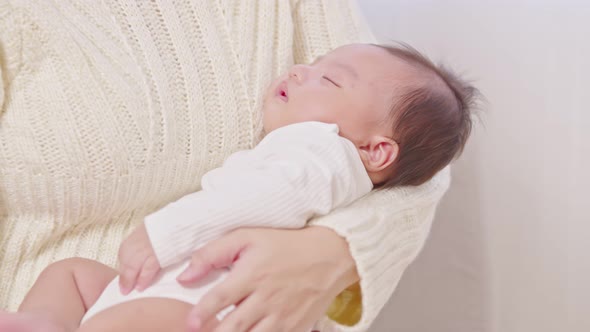 Close up Adorable sleeping newborn baby relax in mother arm safety and comfortable