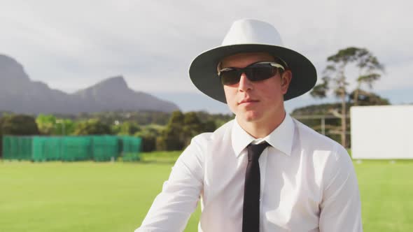 Cricket umpire making signs standing on a cricket pitch