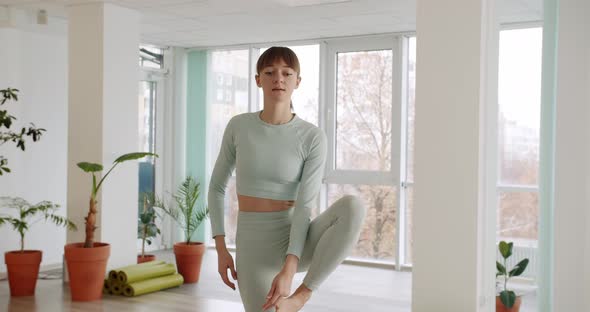 Young Woman Practices a Yoga in Bright Studios Utthita Hasta Padangusthasana