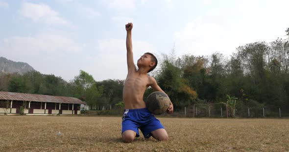 Rural Boy Holding Old Ball And Celebrating