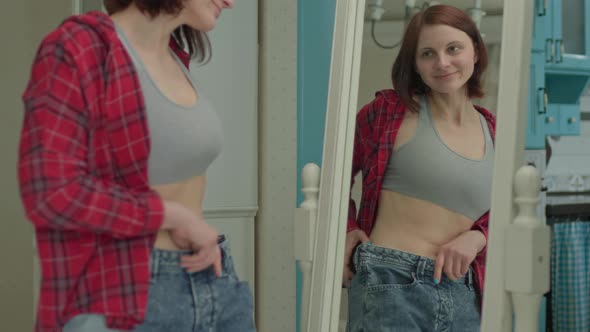 Satisfied Woman Looking at Mirror for Result of Weight Loss