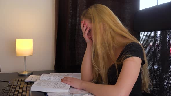 A Young Woman Sits at a Desk in Front of a Computer and Acts Frustrated - Closeup