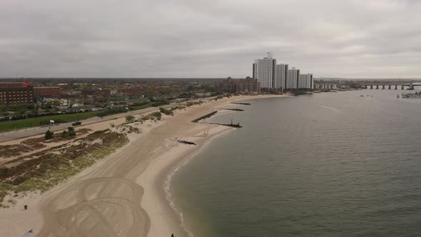 An aerial shot over the East Rockaway Inlet in NY. The drone dolly in to tall white buildings & the