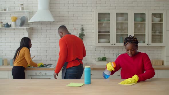 Positive Dad Motivating Teenage Daughters Involved in Housework