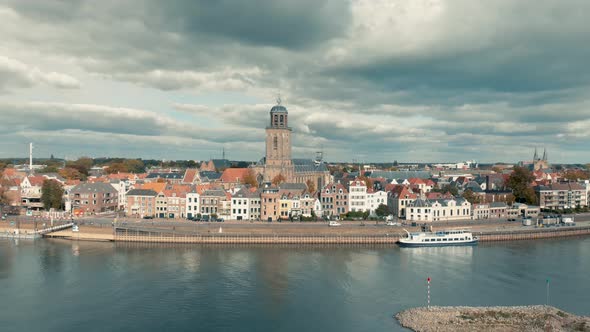 Aerial view of Dutch medieval city Deventer slowly panning up revealing the whole city under a drama