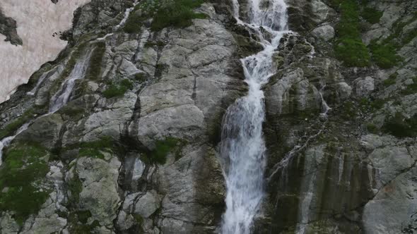 Aerial View of a Glacial Waterfall High in the Mountains on a Sunny Day