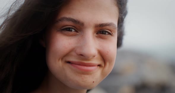 A Young Woman Looks at the Camera with a Smile