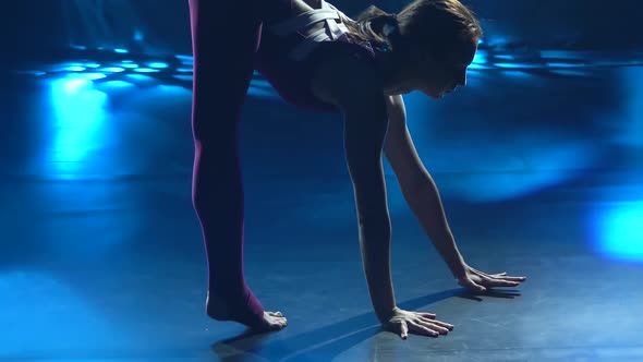 A Girl Gymnast in a Tight Sports Bodysuit Performs Gymnastics Elements and Demonstrates a Wonderful