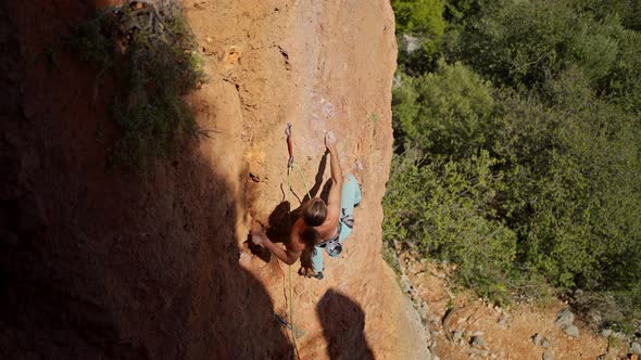 Top View Slow Motion of Strong Man Rock Climber Climbs on Limestone Cliff By Tough Route