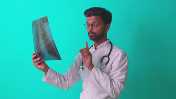 Indian Doctor Showing Chest Bone Film Xray Image in Blue Studio Baclground