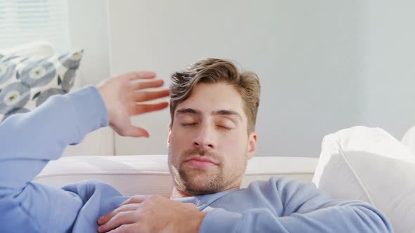 Young man sleeping on sofa at home on a sunny day 4K 4k