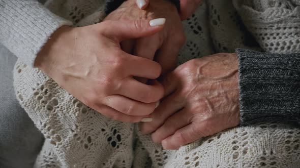 Old Hands of Elderly Senior in the Young Female Hands of Caring Daughter Slow Motion