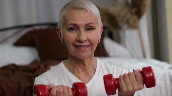 Closeup of Senior Woman with Lifting Dumbbells at Home