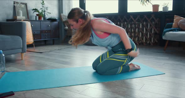 Young Sporty Blonde Caucasian Woman Stretching at Home To Keep Healthy and Fit on Quarantine