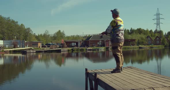 Man Fishing on Wooden Pier Near Lake