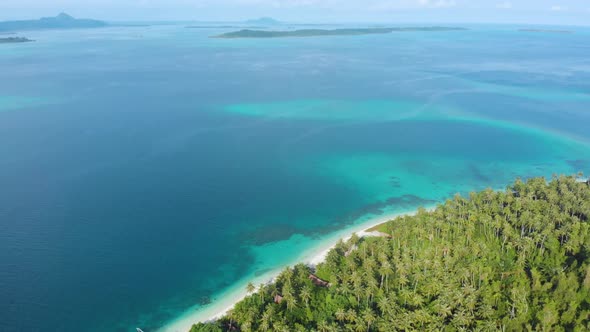 Aerial: flying over exotic white sand beach tropical island secluded destination away from it all