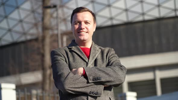 Portrait Face Caucasian Man Looking at Camera Smiling and Waving Hello Greeting Gesture in City