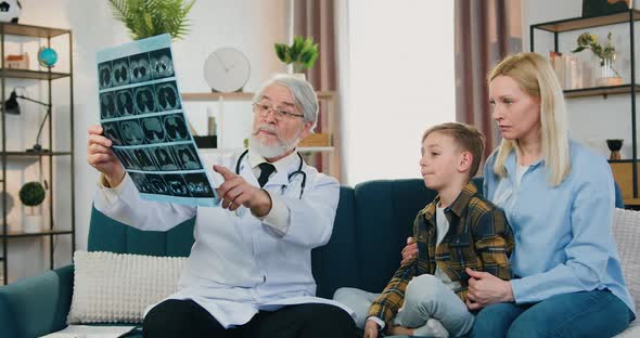 Doctor Visiting Boy Patient and His Mother at Home to Explain Results of X-ray Scan