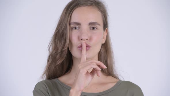 Face of Happy Young Beautiful Woman with Finger on Lips