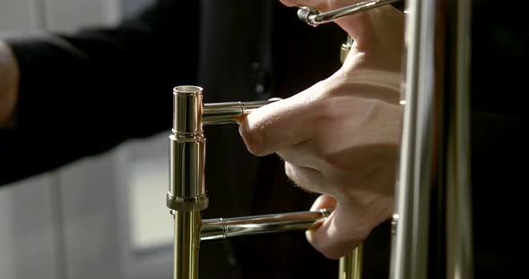 Man Hand Holds Metal Trombone and Fixes Mouthpiece Closeup