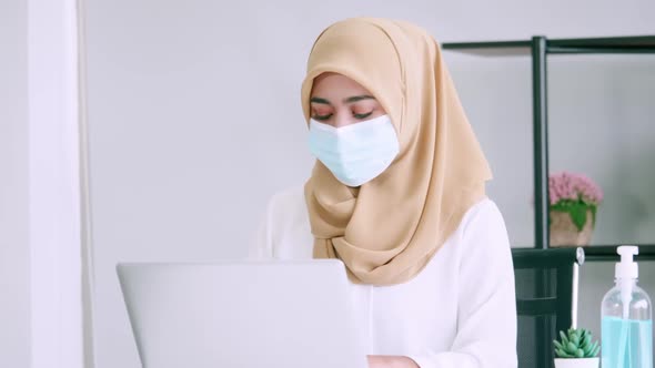 Muslim businesswoman wearing protective masks while working in office.