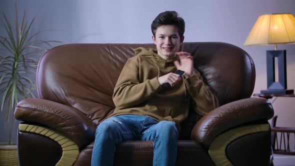 Happy Boy Making Victory Gesture As Team Scoring Goal in TV Match. Portrait of Cheerful Caucasian