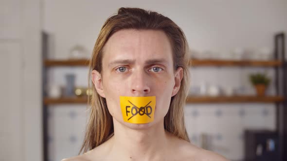 Close Up Portrait of Young Attractive Man with Mouth Sealed on Stick Tape with Text No Food