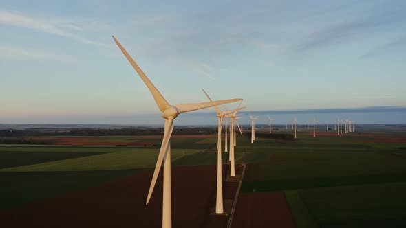 Horizontal Panning From a Drone View of a Massive Wind Farm Among Green Fields
