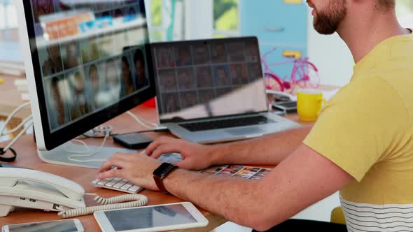 Male executive working on computer while talking on mobile phone 4k