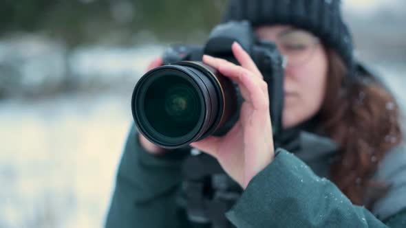 girl photographer takes a picture of landscape outdoors on a winter day