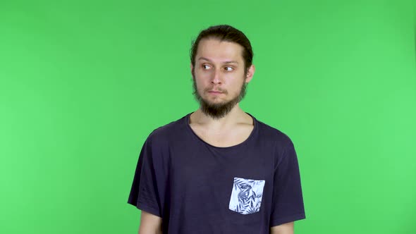 A Young Brunette Man in a Black Tshirt Looks Around Folds His Arms Over His Chest and Hugs His