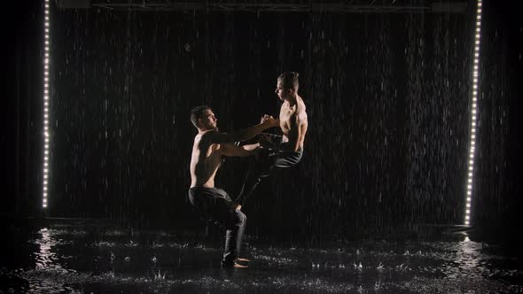 A Group of Acrobatic Gymnasts Perform Complex Acrobatic Exercises While Standing on the Surface of