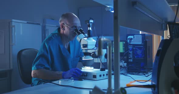 Biologist Analyzing Sample with Microscope