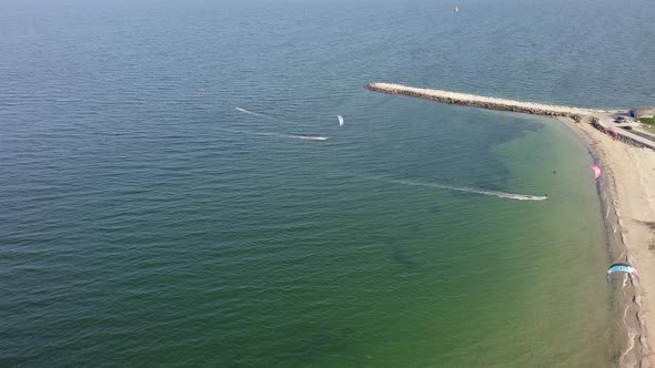 People in Sportswear on Kiteboards Ride on the Black Sea in Bulgaria