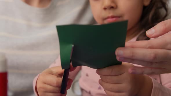 Mother and Child Cutting Color Paper with Scissors