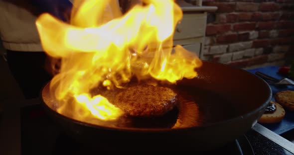 Close Up. Super Slow Motion, Big Fire with Hamburger Steaks From Wok Pan.