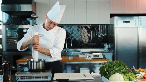 The chef prepares the dish in the professional kitchen of the restaurant.