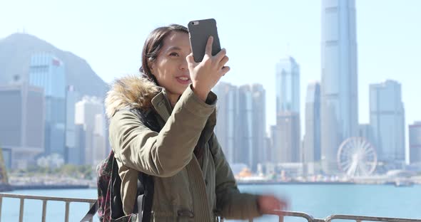 Woman taking video call on cellphone in Hong Kong city