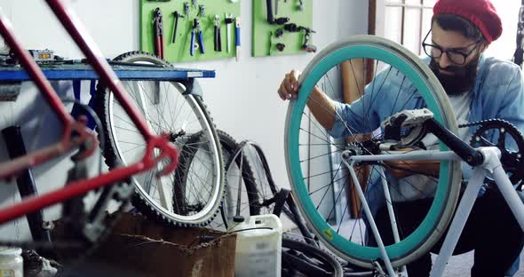 Mechanic repairing bicycle in workshop