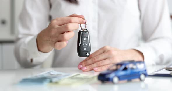 Car Dealer Hands Over Auto Key to Customer Closeup