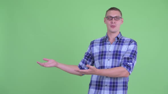 Happy Young Hipster Man Presenting Something