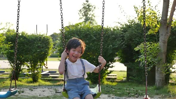 Cute Asian Child Having Fun On Swing In The Park Slow Motion