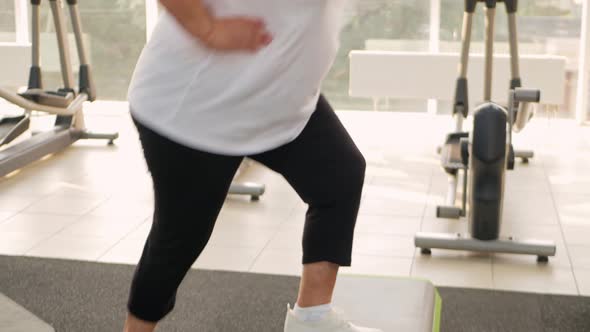 Pensioner Elderly Woman in a Gym on Step Platform