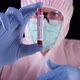 Doctor in white safety uniform, glasses and mask showing positive coronavirus blood test.  - VideoHive Item for Sale