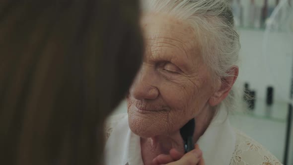 Portrait of Cute Grandmother Talks During Makeup Process