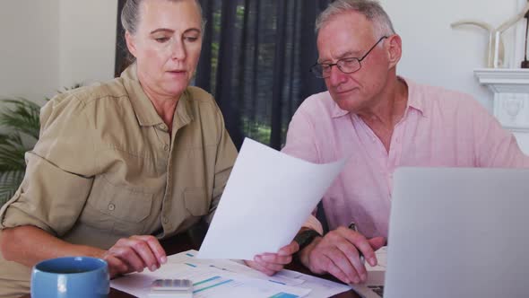 Caucasian senior couple with laptop calculating finances together at home