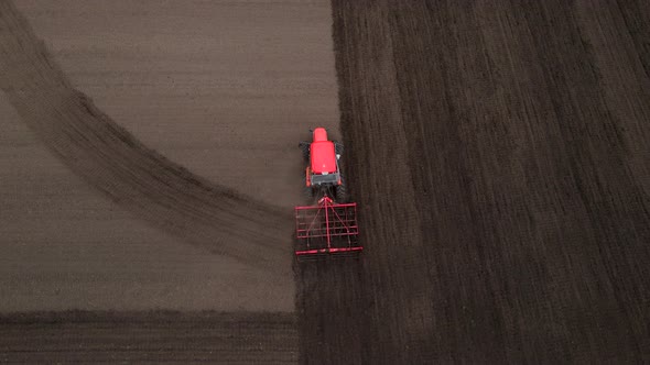 Agricultural Red Small Tractor in the Field Plowing Works in the Field