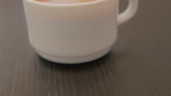 Espresso made in white porcelain cup 4K 2160p UHD footage - Fresh tasty espresso on wooden table sli